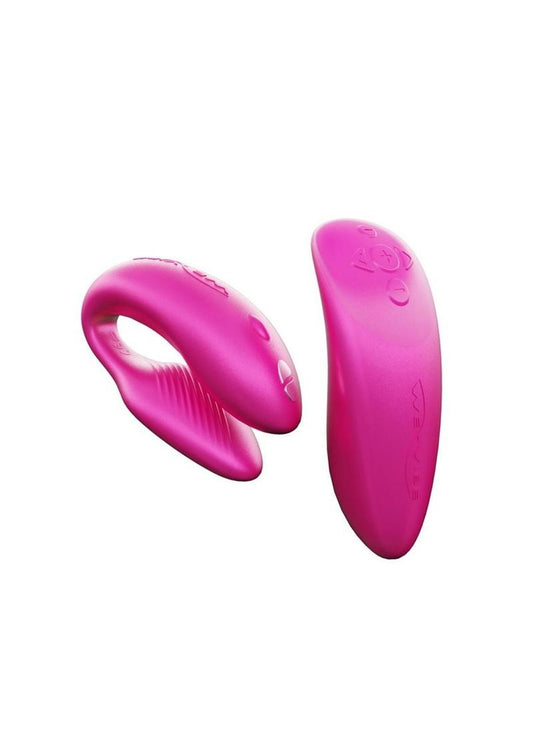 A pink couples vibrator with an interactive squeeze remote control. The vibrator has a clamshell c-shaped curved design, with parts that vibrate externally on the clit and internally on the g-spot. The remote is sleek, small enough to fit in the palm of your hand. The remote has buttons to increase and decrease intensity as well as change the pattern. This toy is hot pink in color.